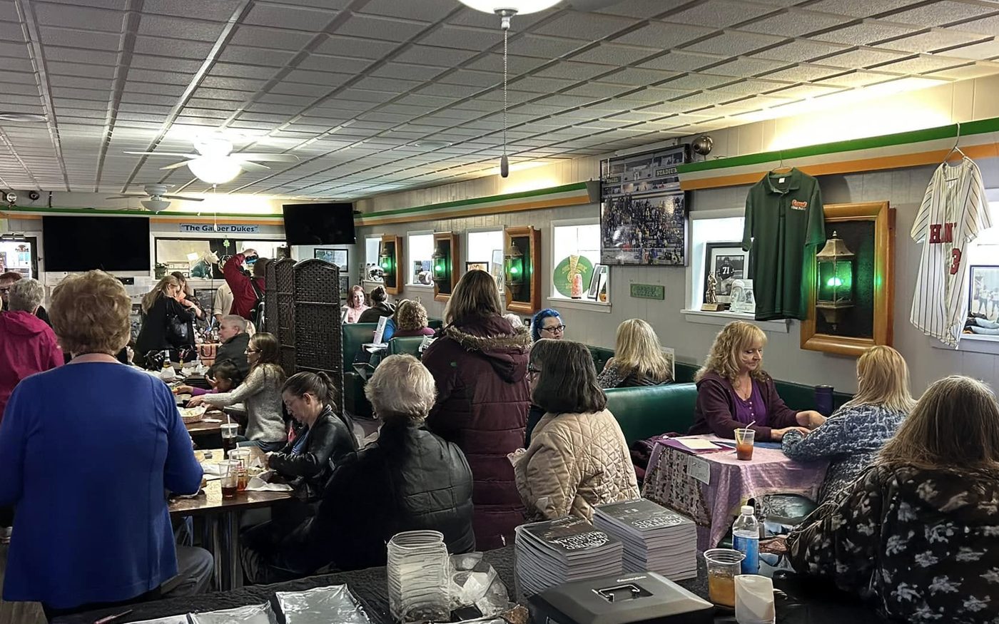 Virgo Room readers working tables at a packed off-site event