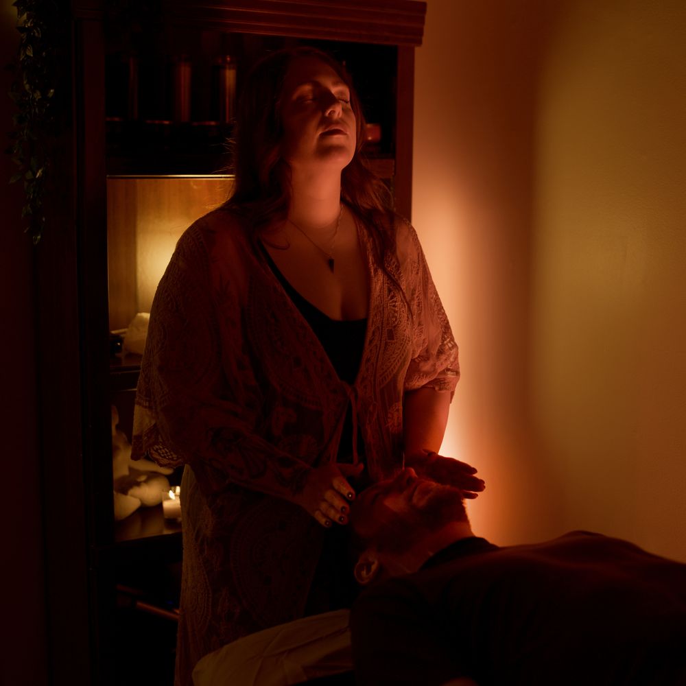 Alicia at the sound bed, hands at a client's head